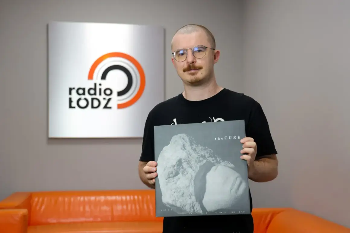 Mężczyzna w okularach trzyma płytę winylową The Cure "Songs of a Lost World" na tle logo Radia Łódź.