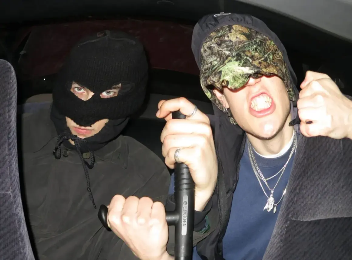 Dwóch mężczyzn w kominiarkach, jeden trzyma tonfę. Ich styl to czysty tonfa rap.