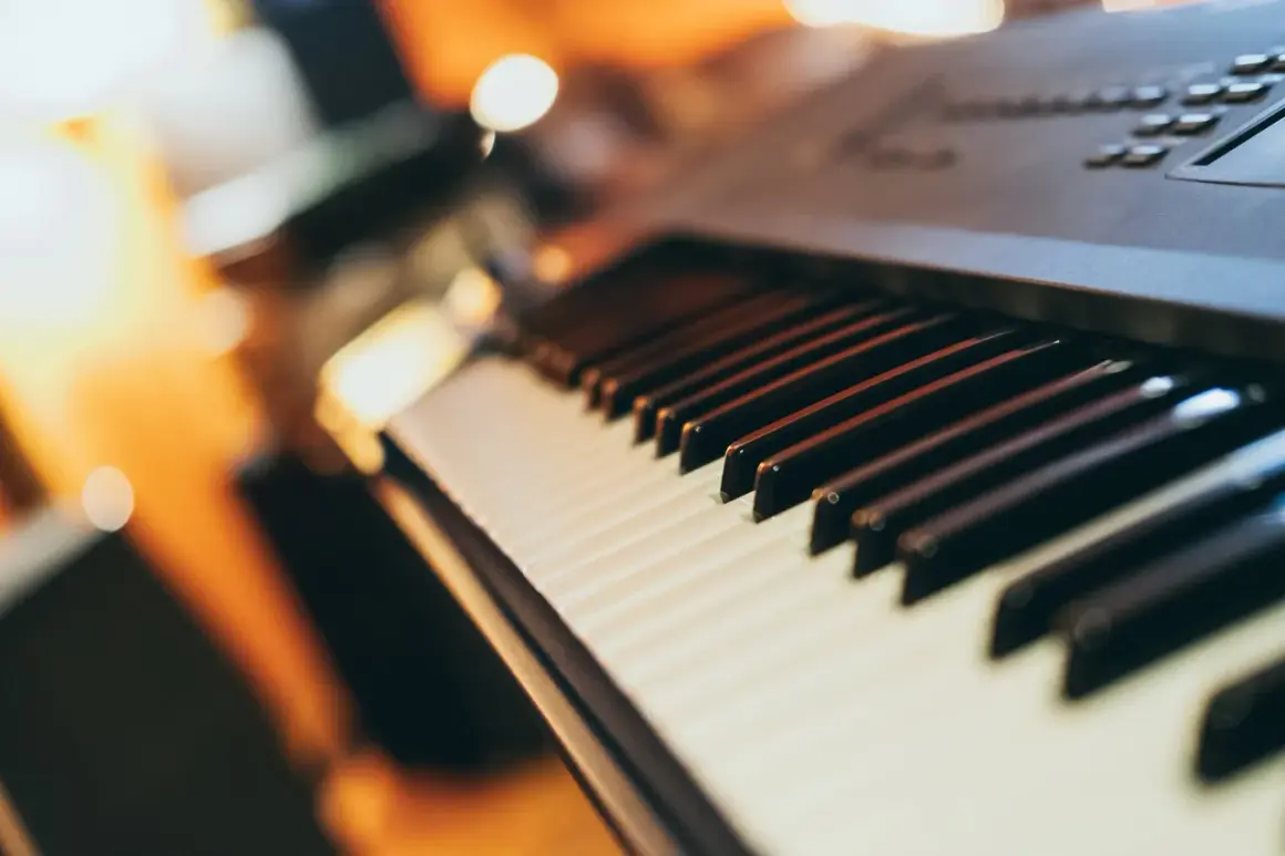 Zbliżenie na klawisze keyboardu. Widoczne białe i czarne klawisze, gotowe do zagrania melodii.