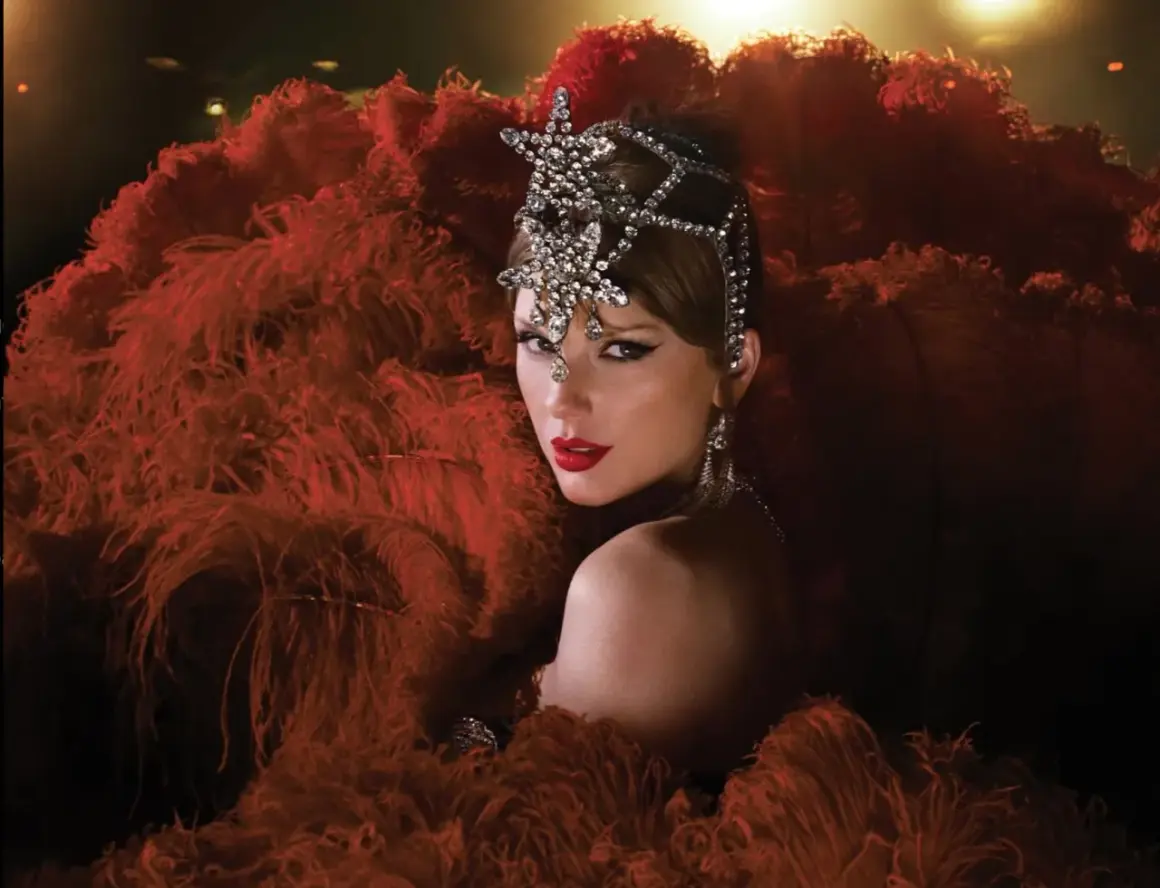 Taylor Swift w teatralnej kreacji z piór i biżuterii. Zastanawiasz się, ile piosenek ma Taylor Swift?