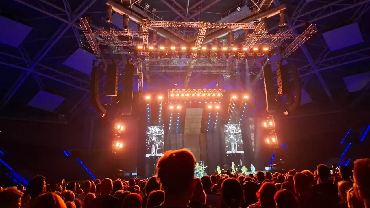 Koncert Lenny Kravitz w Łodzi. Tłum widzów pod sceną, oświetloną pomarańczowymi światłami i ekranami z wizerunkiem artysty.