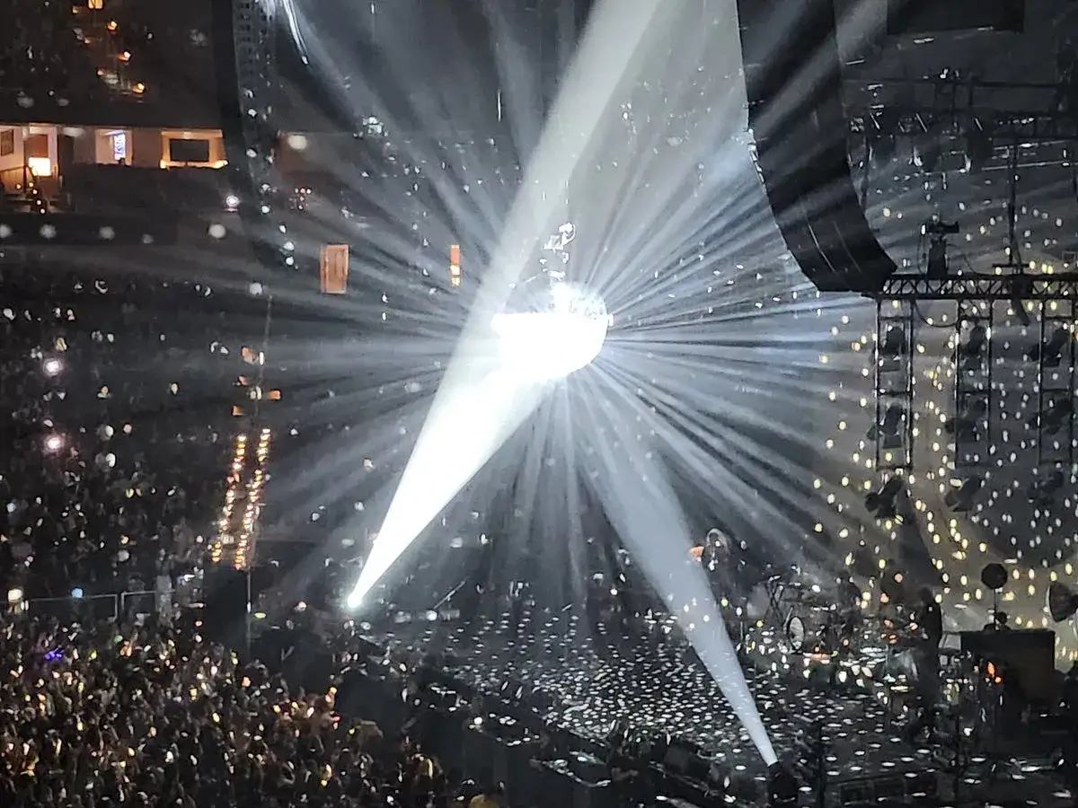 Niesamowite światła na koncertach Arctic Monkeys. Tłum szaleje, a scena rozświetlona jest dyskotekową kulą i laserami.