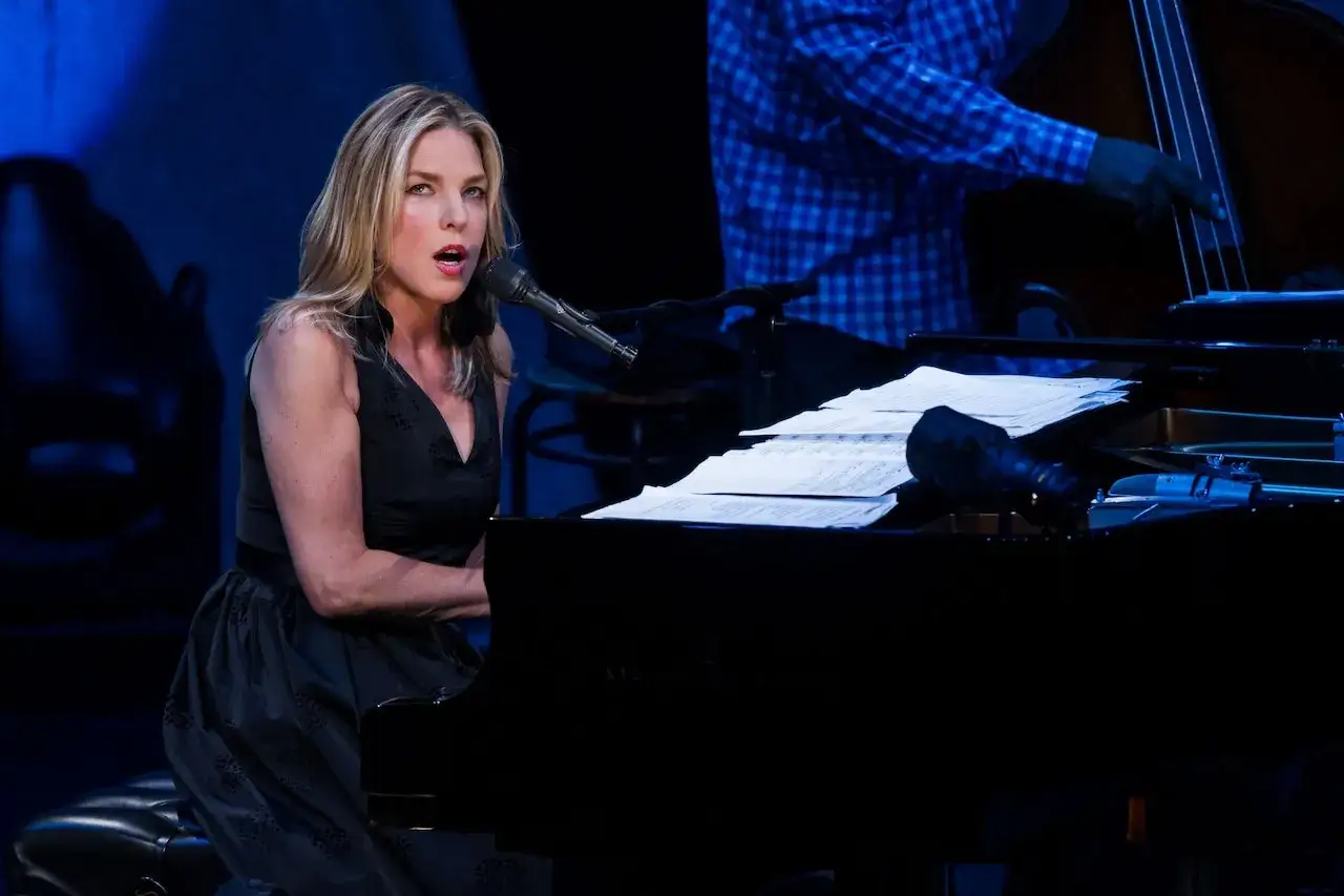 Diana Krall koncert: wokalistka i pianistka w czarnej sukience śpiewa przy fortepianie, obok kontrabasista.
