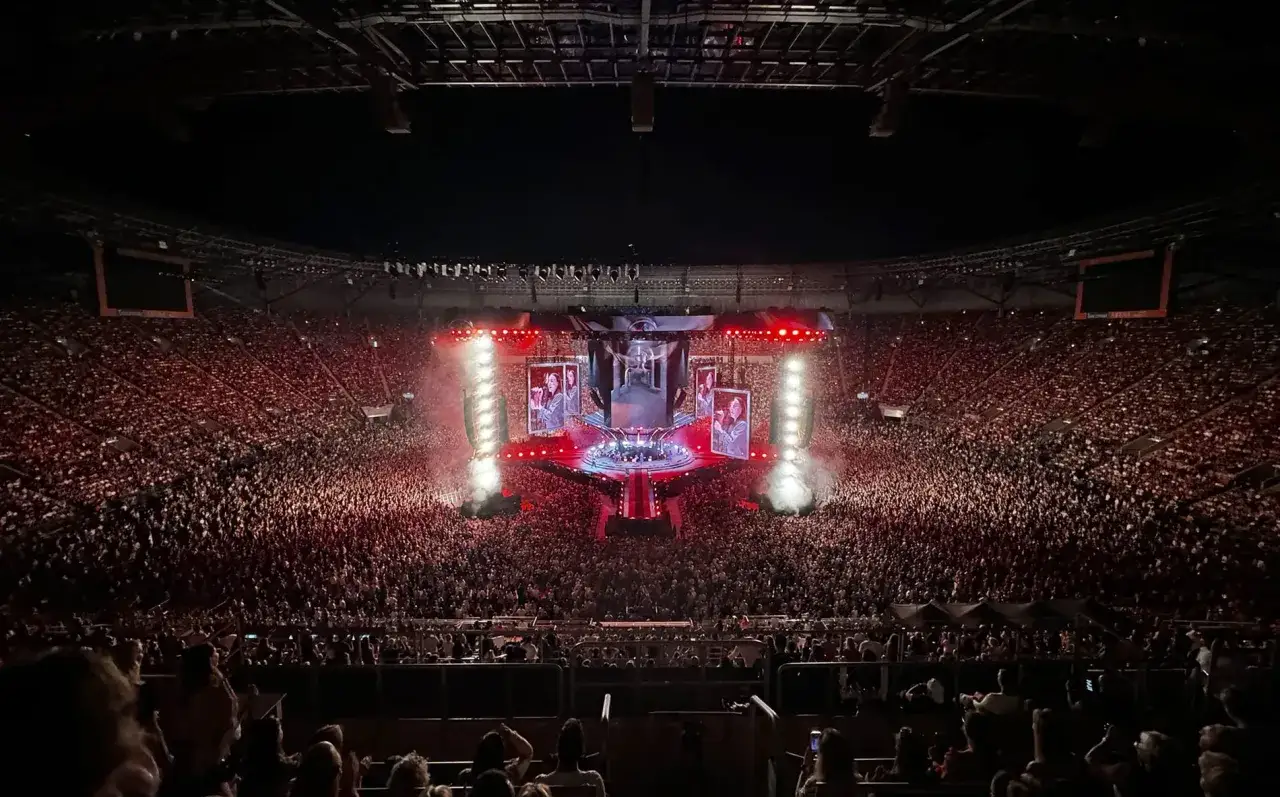 Ogromny tłum na koncercie Podsiadło we Wrocławiu. Scena oświetlona, widać ekrany z artystą.