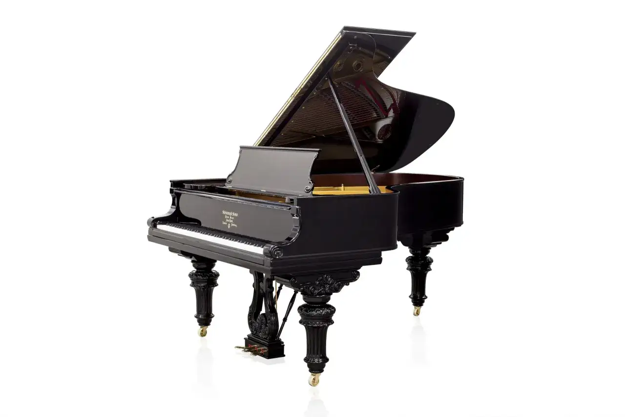 Elegancki, czarny fortepian z otwartą klapą, prezentujący swoje wnętrze. To instrument, kt&oacute;ry zachwyca zar&oacute;wno wyglądem, jak i dźwiękiem, w przeciwieństwie do mniejszego pianina.