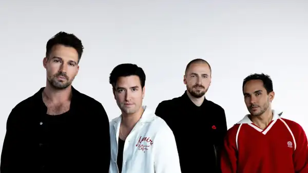 Czterech mężczyzn z zespołu Big Time Rush pozuje do zdjęcia na białym tle.