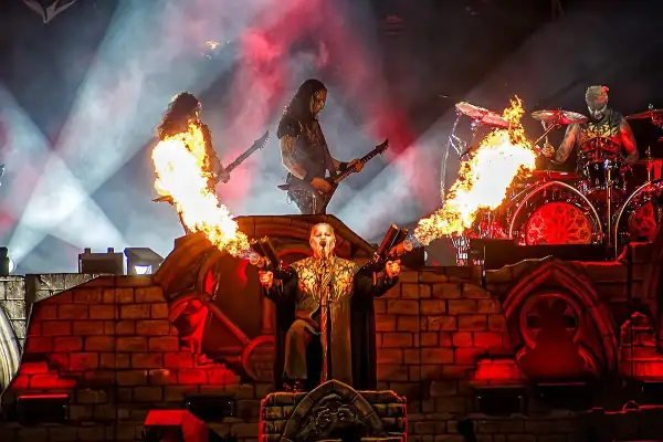 Płomienie i dym na koncercie Powerwolf. Wokalista z miotaczami ognia, gitarzyści i perkusista w akcji.