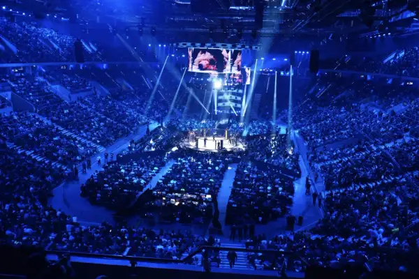 Widok z góry na arenę sportową z widownią, ringiem i ekranem.