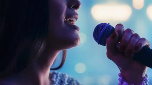 Kobieta śpiewa do mikrofonu. Czy to playback? Nie, czuć emocje w jej głosie.
