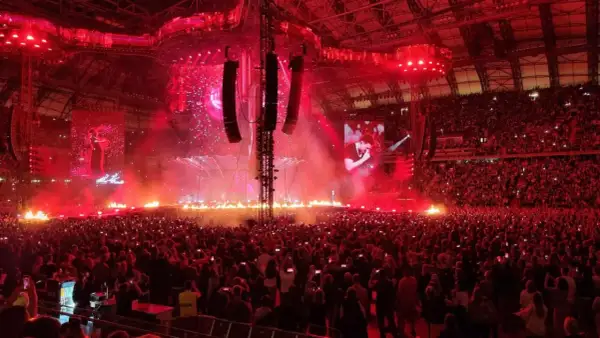 Koncert Dawida Podsiadło w Poznaniu: scena z ogniem, tłum ludzi i ekrany z artystą.