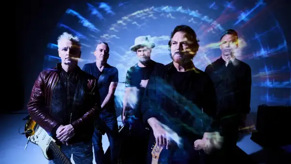 Zespół Pearl Jam Polska w stylizacji z lat 90. na tle psychodelicznych wizualizacji.