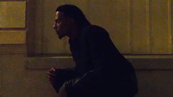 Playboi Carti w Polsce, siedzi w mroku, czekając na coś.
