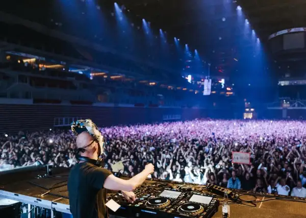 DJ Boris Brejcha w masce gra dla tłumu fanów na koncercie w hali.