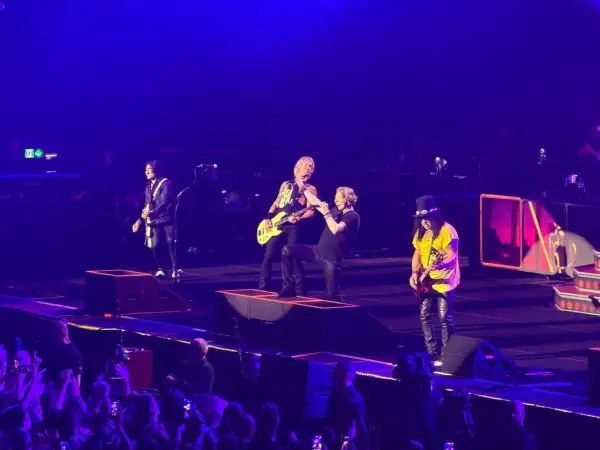 Zespół Guns N' Roses na scenie podczas koncertu w Gliwicach, w tle publiczność.