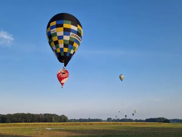 Balony unoszą się na niebie, przypominając o znaczeniu 99 luftballons. W oddali widać więcej balonów.