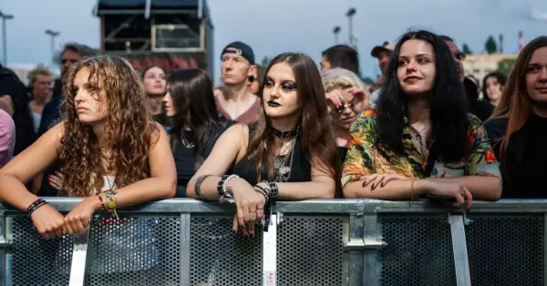 Młode kobiety z bransoletkami i naszyjnikami, czekające na koncert podczas krakowskiego festiwalu muzycznego.