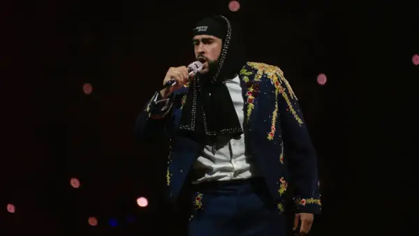 Bad Bunny w ozdobnej marynarce śpiewa na koncercie, marząc o występie w Polsce.